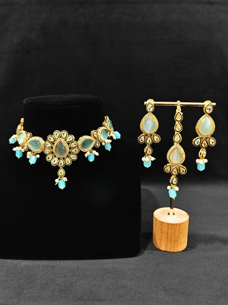 Close-up of an ornate traditional Sky Blue Choker jewellery set and earrings and maangtikka with Kundan, Monalisa Stone, American Diamonds, Beads and Reverse American Diamonds and tumble stones. A graceful woman wearing a trending Colored Stone necklace for a 2026 wedding celebration. Elegant wedding jewelry look featuring a premium artificial Colored Stone necklace.