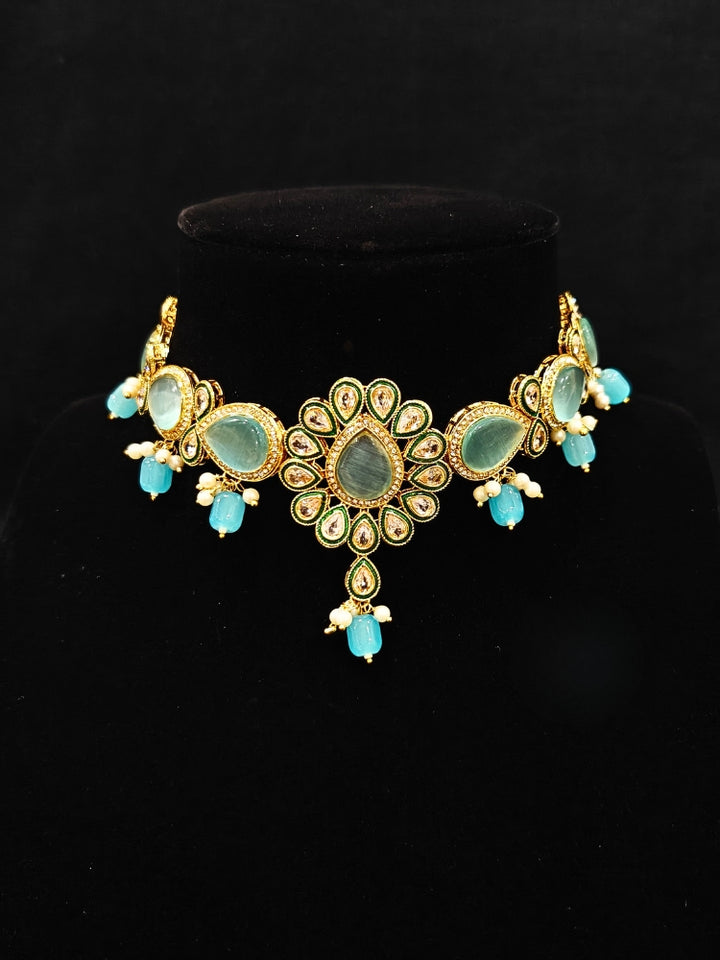 Close-up of an ornate traditional Sky Blue Choker jewellery set and earrings and maangtikka with Kundan, Monalisa Stone, American Diamonds, Beads and Reverse American Diamonds and tumble stones. A graceful woman wearing a trending Colored Stone necklace for a 2026 wedding celebration. Elegant wedding jewelry look featuring a premium artificial Colored Stone necklace.