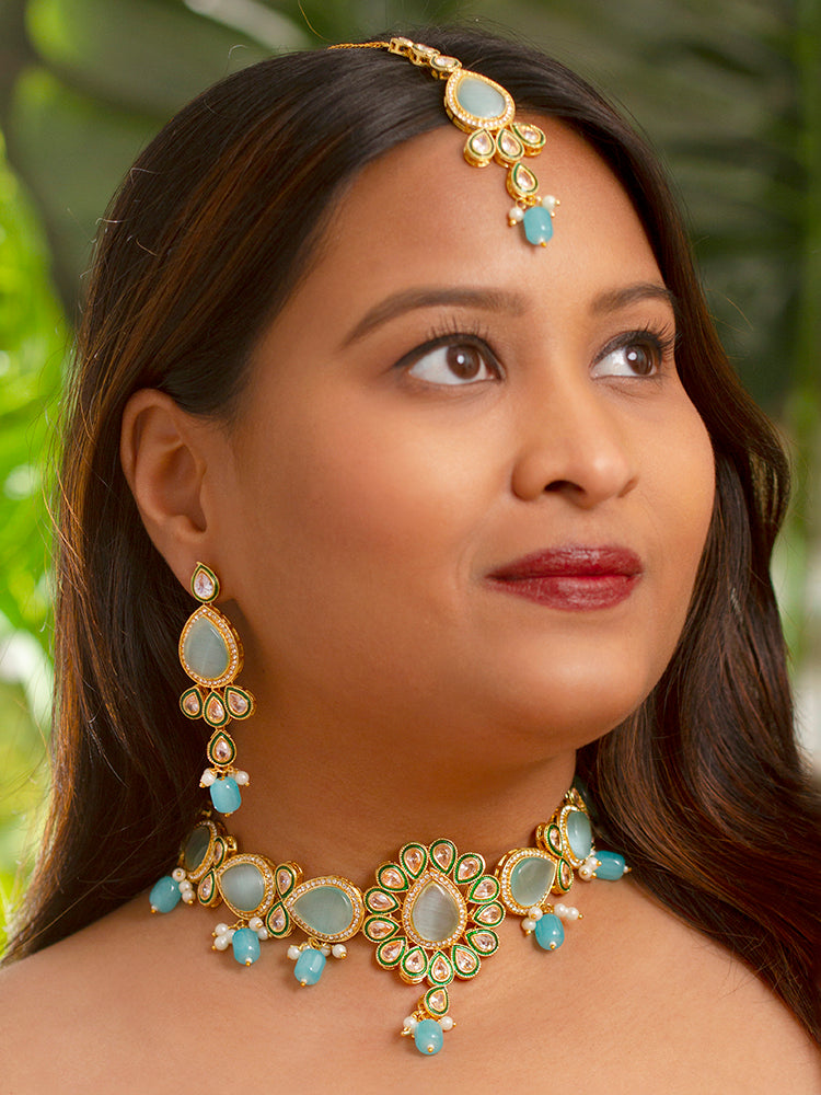 Close-up of a women wearing an ornate traditional Sky Blue Choker jewellery set and earrings and maangtikka with Kundan, Monalisa Stone, American Diamonds, Beads and Reverse American Diamonds and tumble stones. A graceful woman wearing a trending Colored Stone necklace for a 2026 wedding celebration. Elegant wedding jewelry look featuring a premium artificial Colored Stone necklace.