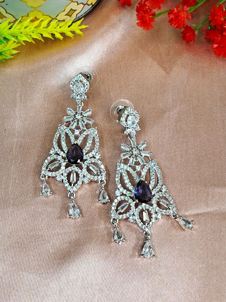Close-up of an ornate Western (Silver Polish) Purple Diamond Earrings with American Diamond and Colored Stones. Woman wearing statement artificial American Diamond earrings for a wedding guest look in India. Elegant party wear styled with high-quality imitation American Diamond earrings.