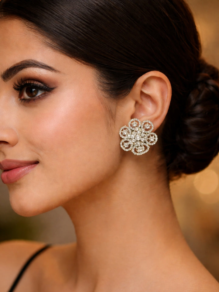 Close-up of a woman wearing an ornate Western (Silver Polish) Diamond Studs Earrings with American Diamond. Festive Diwali outfit styled with an American diamond artificial Earrings. Close-up shot of a high-quality American diamond artificial Earrings worn for festive celebrations.