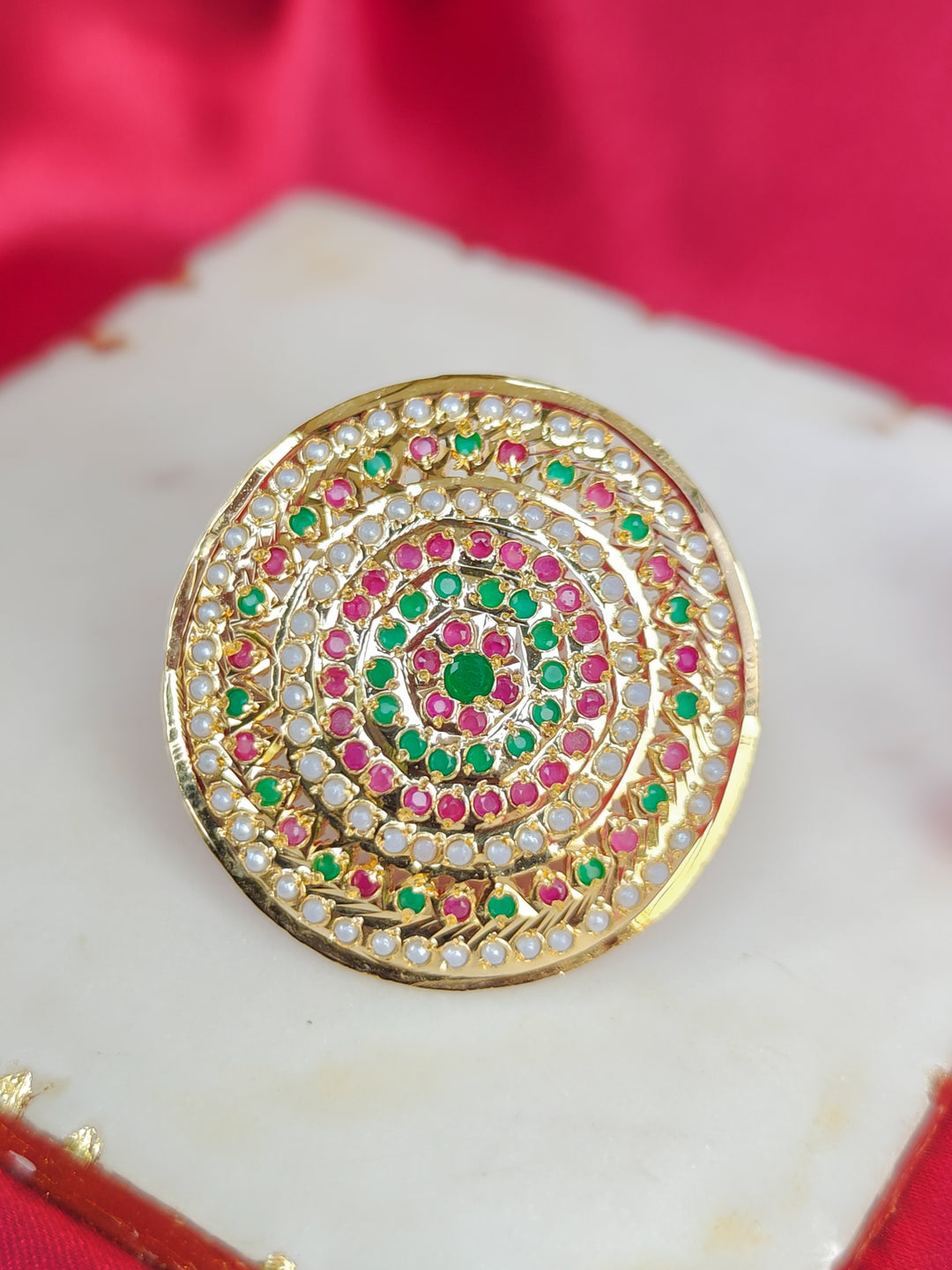 Close-up of an ornate traditional White, Multi-color jadau gold Ring with pearl and Color Stone. Styling a premium imitation jadau ring with festive attire. Saree styling inspiration featuring an adjustable artificial Jadau ring.