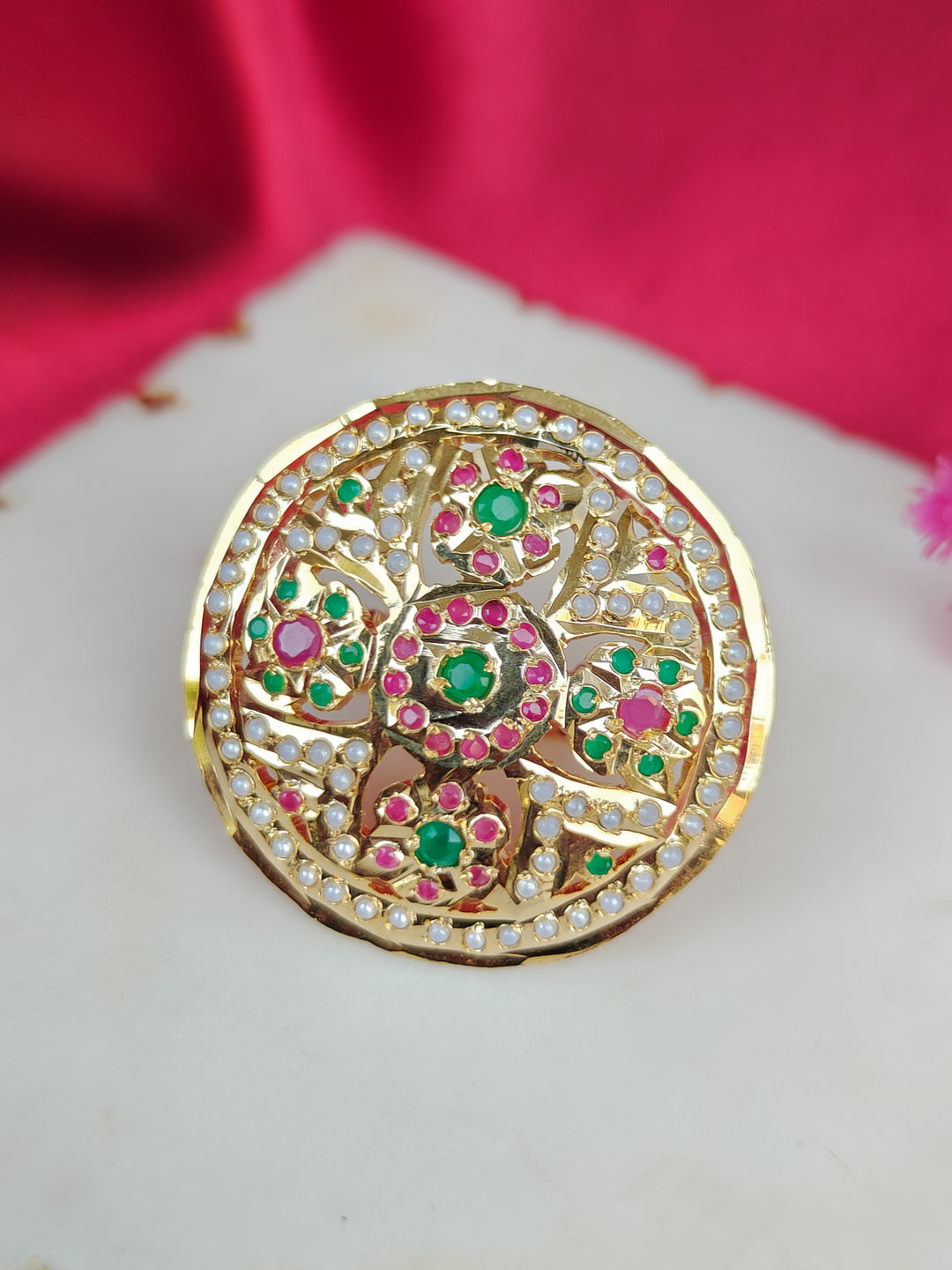 Close-up of an ornate traditional White, Multi-color jadau gold Ring with pearl and Color Stone. Woman wearing a trendy artificial Jadau ring for wedding season in India. Festive Diwali look completed with a artificial Jadau ring.