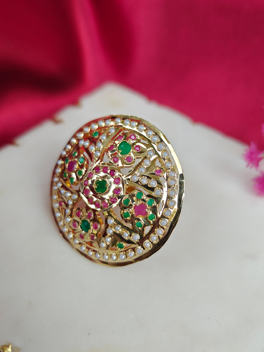 Close-up of an ornate traditional White, Multi-color jadau gold Ring with pearl and Color Stone. Woman wearing a trendy artificial Jadau ring for wedding season in India. Festive Diwali look completed with a artificial Jadau ring.