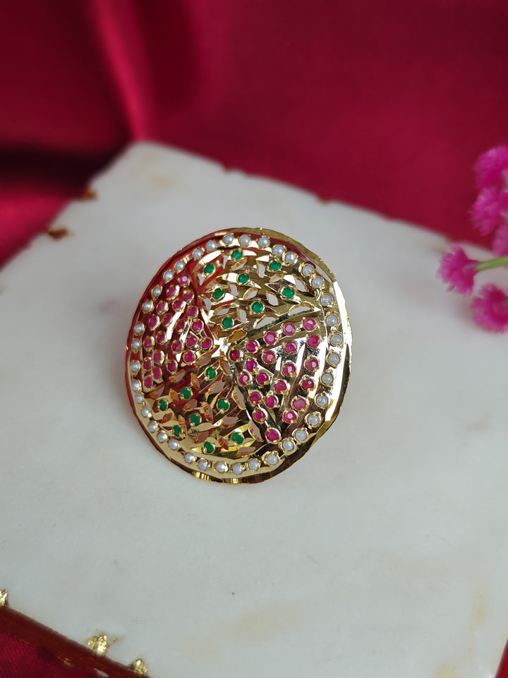 Close-up of an ornate traditional White, Multi-color jadau gold Ring with pearl and Color Stone. Styling a premium imitation jadau ring with festive attire. Close-up of a high-quality imitation jadau ring with intricate detailing.