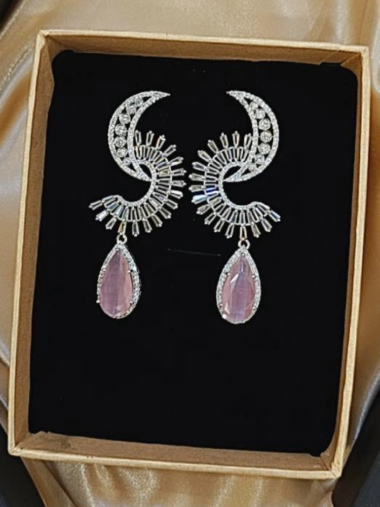Close-up of an ornate Western (Silver Polish) Pink Long Diamond  Earrings with American Diamond and Pink Colored Stones. Cocktail party outfit paired with sparkling artificial American Diamond earrings. Reception-ready look completed with statement artificial American Diamond jewelry earrings.