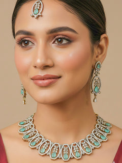 Close-up of a woman wearing an ornate Indo-Western American diamond and Colored Stone Collar jewellery set and earrings and maangtikka with American diamond and Colored Stone. A woman wearing a luxury American diamond necklace set styled beautifully for a wedding guest look in India.