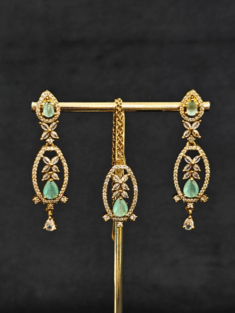 Close-up of an ornate Indo-Western American diamond and Colored Stone Collar jewellery set, earrings and maangtikka with American diamond and Colored Stone. A sparkling American diamond necklace for reception night.