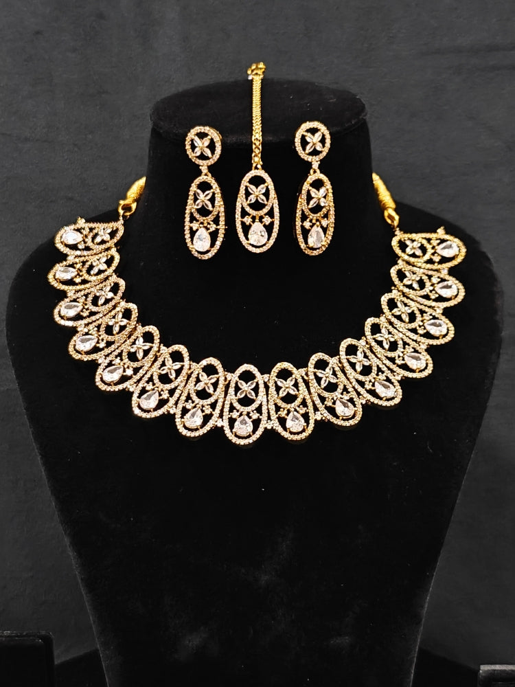 Close-up of an ornate Indo-Western American diamond Collar jewellery set, earrings and maangtikka with American diamond. A sparkling American diamond necklace for reception night.