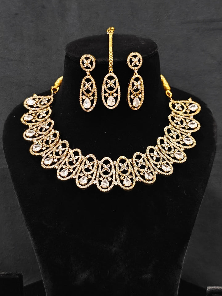Close-up of an ornate Indo-Western American diamond Collar jewellery set, earrings and maangtikka with American diamond. A sparkling American diamond necklace for reception night.
