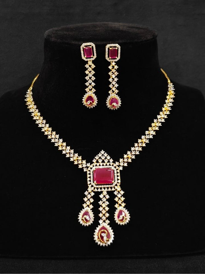 Close-up of an ornate Western (Gold Polish) Collar jewellery set and earrings with American Diamond and Colored Stones. Party wear outfit completed with a lightweight American diamond necklace. Elegant wedding jewelry look featuring a premium artificial American diamond necklace.
