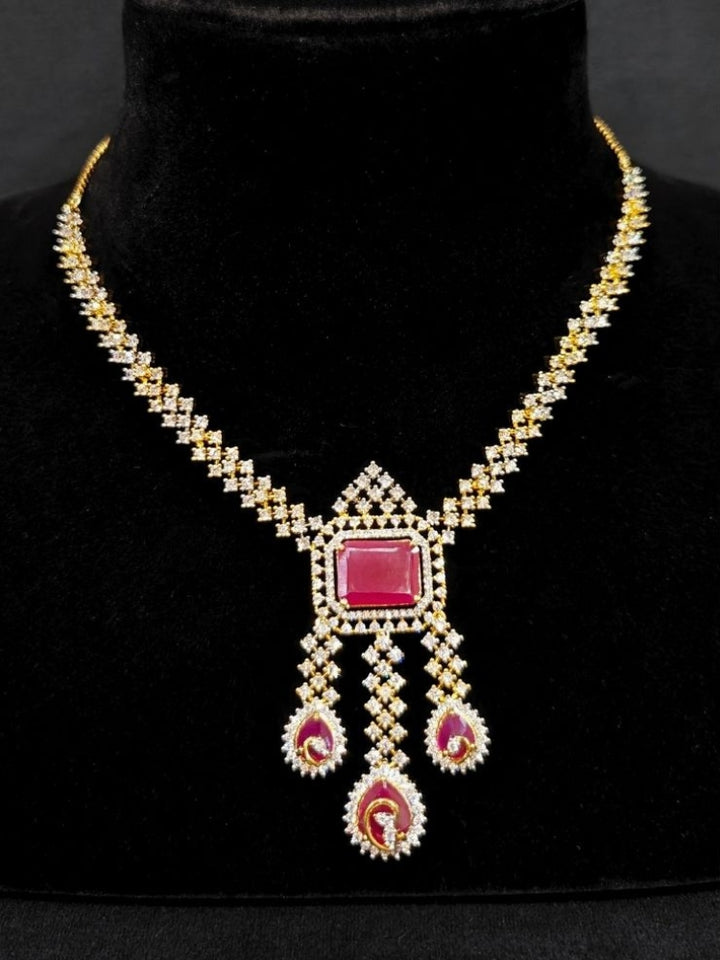 Close-up of an ornate Western (Gold Polish) Collar jewellery set and earrings with American Diamond and Colored Stones. Party wear outfit completed with a lightweight American diamond necklace. Elegant wedding jewelry look featuring a premium artificial American diamond necklace.