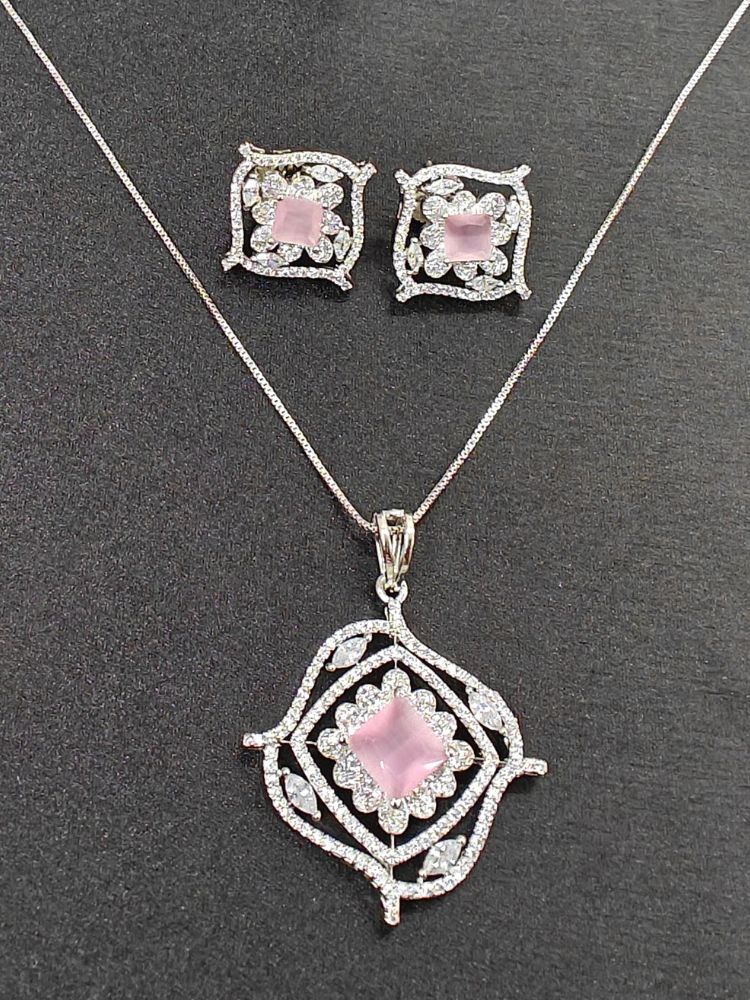 The Stella Mint Pink Pendant Set features a silver necklace and matching ethnic earrings with ornate, diamond-studded designs and central square mint Pink pendants, ideal wedding ceremony jewelry, displayed on a striking black background.
