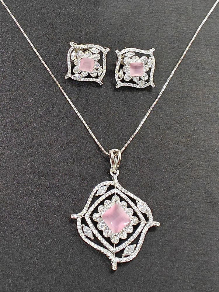 The Stella Mint Pink Pendant Set features a silver necklace and matching ethnic earrings with ornate, diamond-studded designs and central square mint Pink pendants, ideal wedding ceremony jewelry, displayed on a striking black background.