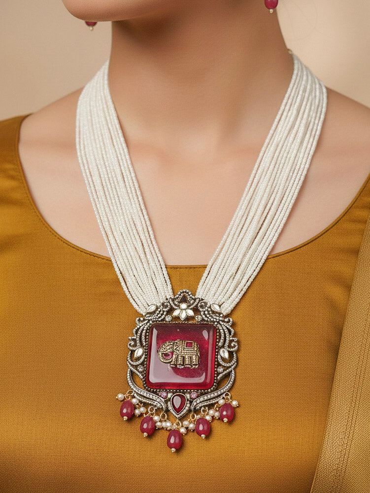 Close-up of a woman wearing an ornate traditional Ruby Pink (Mehendi Polish) Colored Stone jewellery set and earrings with American Diamond, Ruby Pink Colored Stones, Tumble Beads, Kundan and Pearls. Mehendi function outfit styled with a lightweight American Diamond necklace.
