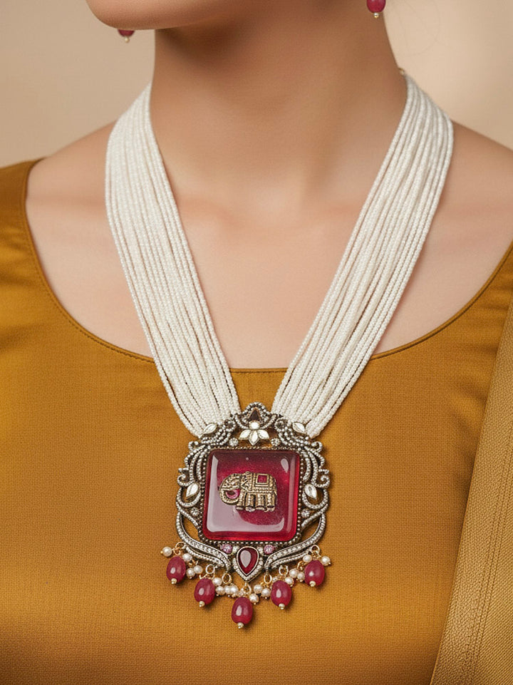 Close-up of a woman wearing an ornate traditional Ruby Pink (Mehendi Polish) Colored Stone jewellery set and earrings with American Diamond, Ruby Pink Colored Stones, Tumble Beads, Kundan and Pearls. Mehendi function outfit styled with a lightweight American Diamond necklace.
