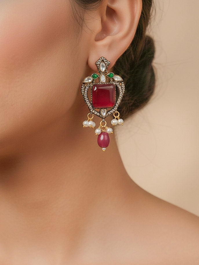 Close-up of a woman wearing an ornate traditional Ruby Pink (Mehendi Polish) Colored Stone jewellery set and earrings with American Diamond, Ruby Pink Colored Stones, Tumble Beads, Kundan and Pearls. Mehendi function outfit styled with a lightweight American Diamond necklace.
