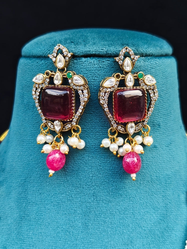 Close-up of an ornate traditional Ruby Pink (Mehendi Polish) Colored Stone jewellery set and earrings with American Diamond, Ruby Pink Colored Stones, Tumble Beads, Kundan and Pearls. Mehendi function outfit styled with a lightweight American Diamond necklace.