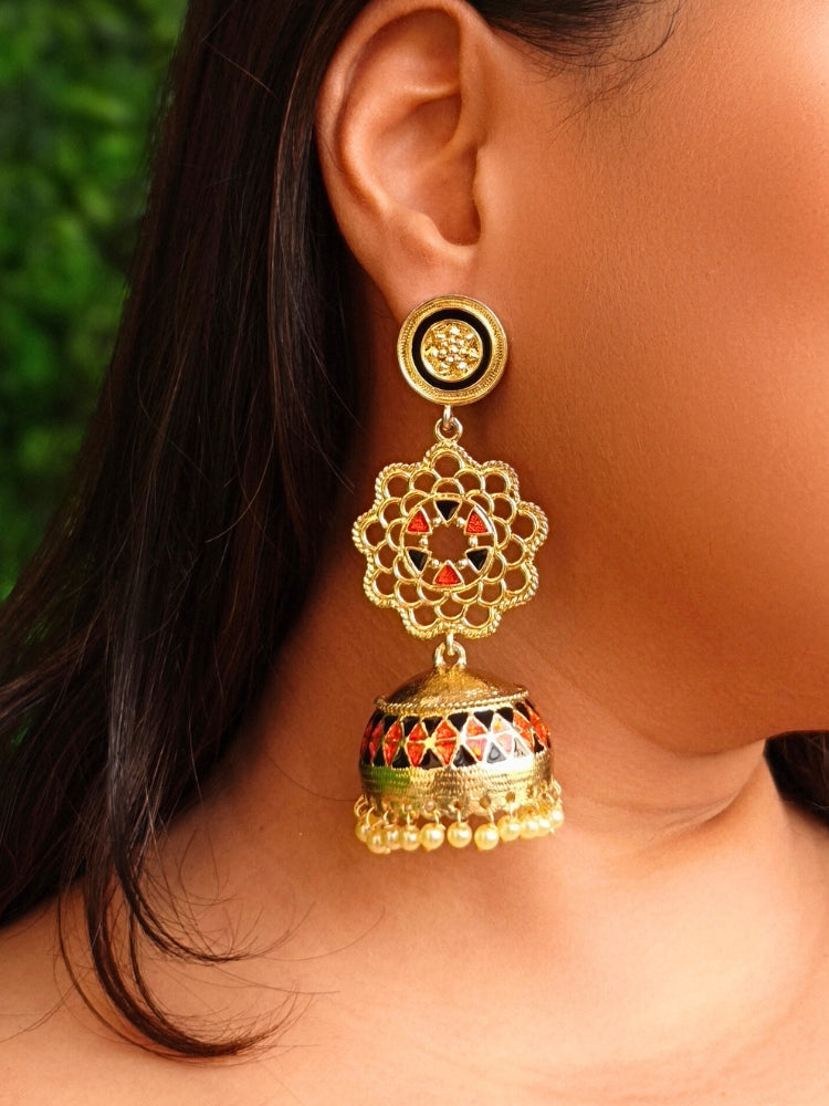 Close-up of a woman wearing an ornate traditional (Gold Polish) Orange & Black Long Earrings Set with Meenakari and Pearl. Saree styling inspiration featuring elegant imitation Meenakari earrings. Woman wearing trendy artificial Meenakari earrings for a 2026 wedding celebration in India.