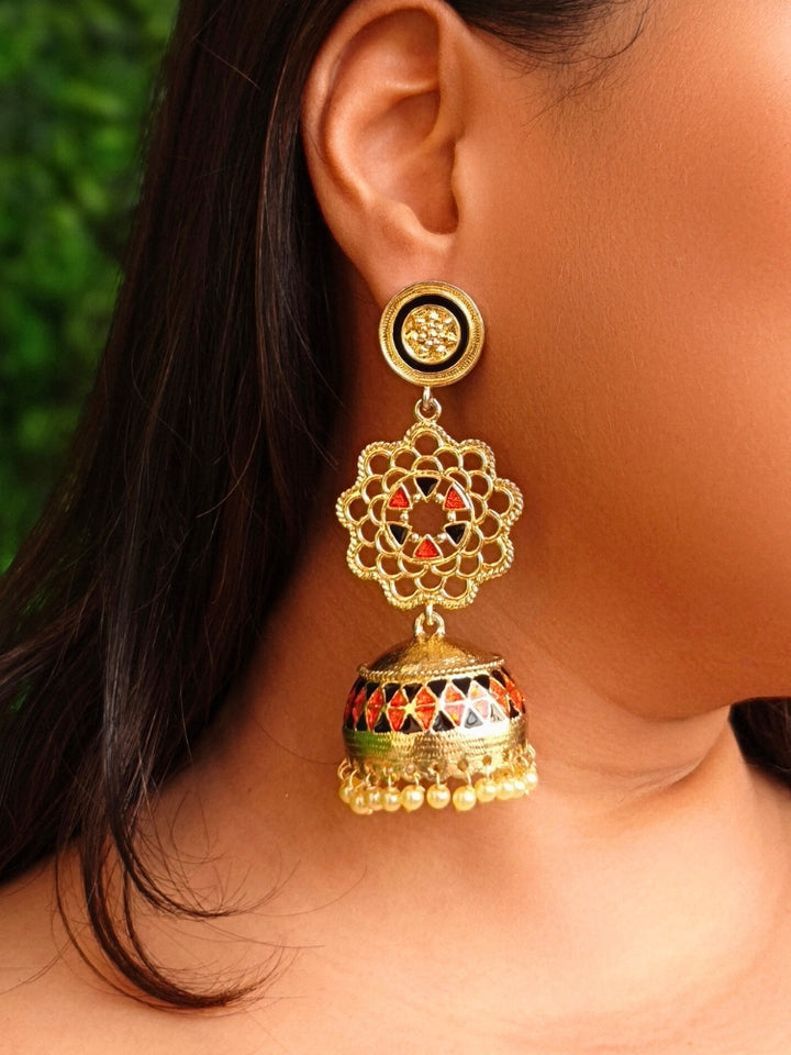 Close-up of a woman wearing an ornate traditional (Gold Polish) Orange & Black Long Earrings Set with Meenakari and Pearl. Saree styling inspiration featuring elegant imitation Meenakari earrings. Woman wearing trendy artificial Meenakari earrings for a 2026 wedding celebration in India.