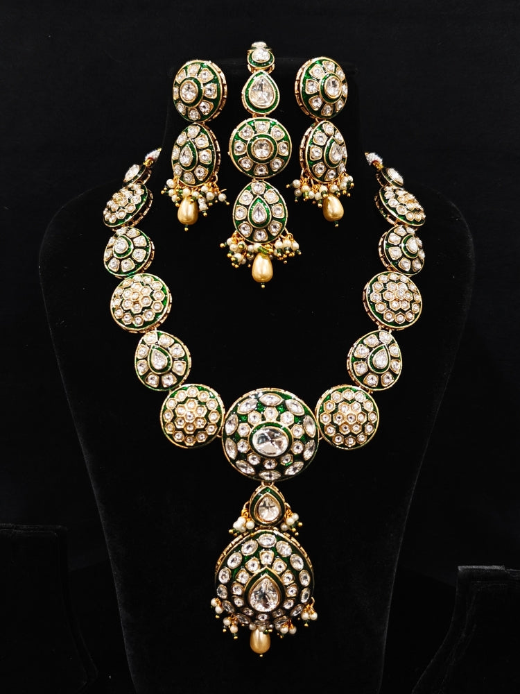 Close-up of an ornate traditional Green Jewelry Set, Earrings and Mangtikka with Kundan. Bride wearing a traditional Kundan artificial necklace set for her wedding ceremony. Woman wearing trending Kundan artificial jewelry for wedding season in India.