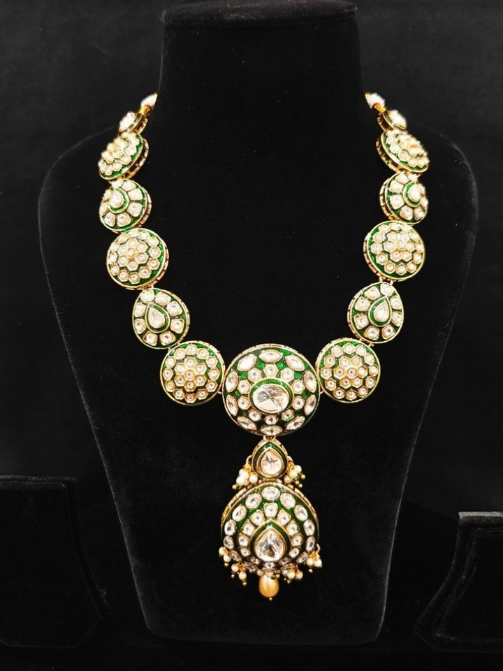 Close-up of an ornate traditional Green Jewelry Set, Earrings and Mangtikka with Kundan. Bride wearing a traditional Kundan artificial necklace set for her wedding ceremony. Woman wearing trending Kundan artificial jewelry for wedding season in India.
