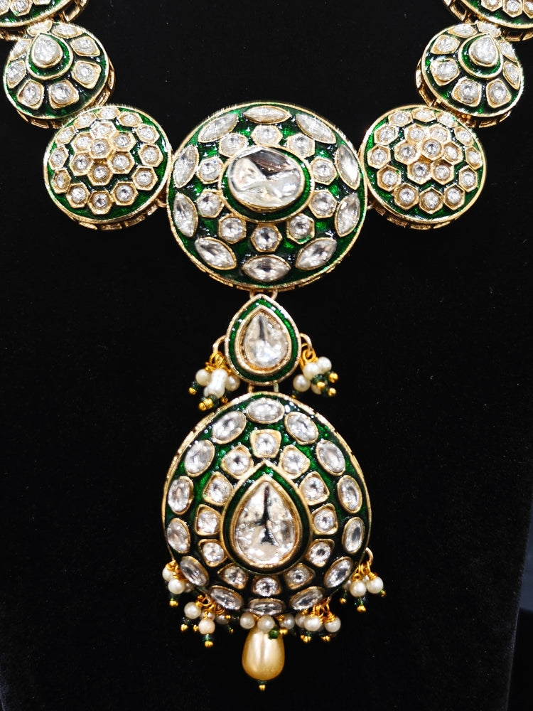 Close-up of an ornate traditional Green Jewelry Set, Earrings and Mangtikka with Kundan. Bride wearing a traditional Kundan artificial necklace set for her wedding ceremony. Woman wearing trending Kundan artificial jewelry for wedding season in India.