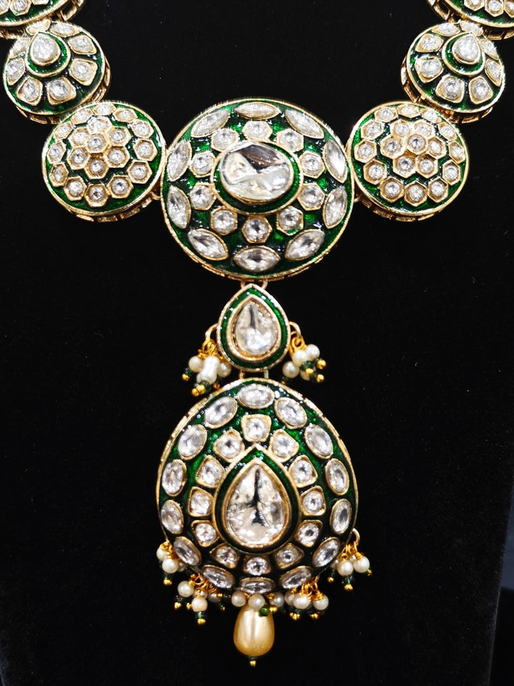 Close-up of an ornate traditional Green Jewelry Set, Earrings and Mangtikka with Kundan. Bride wearing a traditional Kundan artificial necklace set for her wedding ceremony. Woman wearing trending Kundan artificial jewelry for wedding season in India.