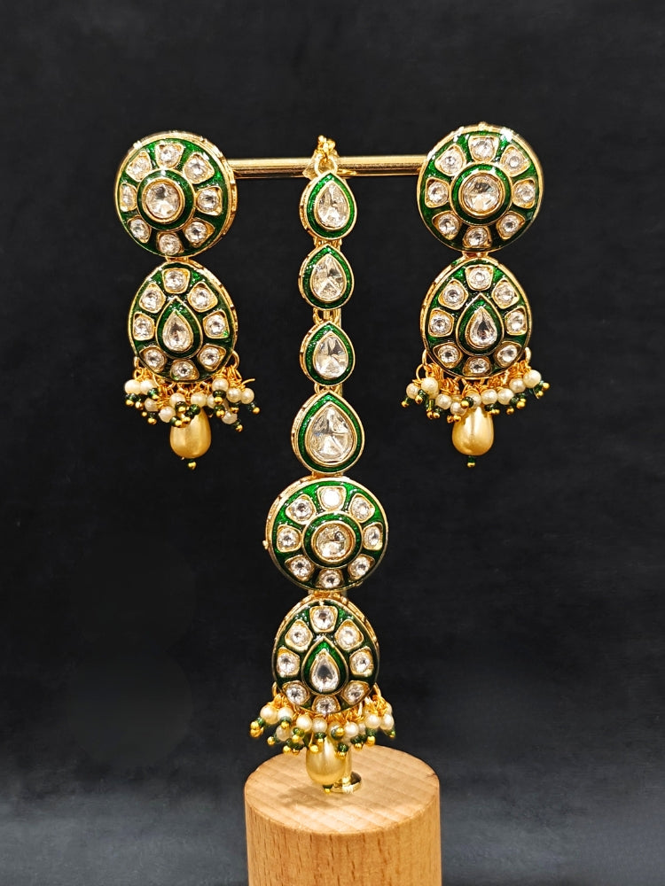 Close-up of an ornate traditional Green Jewelry Set, Earrings and Mangtikka with Kundan. Bride wearing a traditional Kundan artificial necklace set for her wedding ceremony. Woman wearing trending Kundan artificial jewelry for wedding season in India.