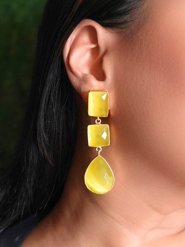 Close-up of a woman wearing an ornate Western Long Earrings with Yellow Colored Stone. Indo-western dress styled with lightweight artificial Colored Stone earrings. 