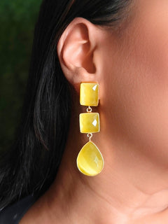 Close-up of a woman wearing an ornate Western Long Earrings with Yellow Colored Stone. Indo-western dress styled with lightweight artificial Colored Stone earrings. 