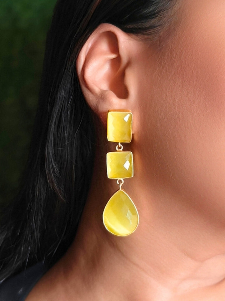 Close-up of a woman wearing an ornate Western Long Earrings with Yellow Colored Stone. Indo-western dress styled with lightweight artificial Colored Stone earrings. 