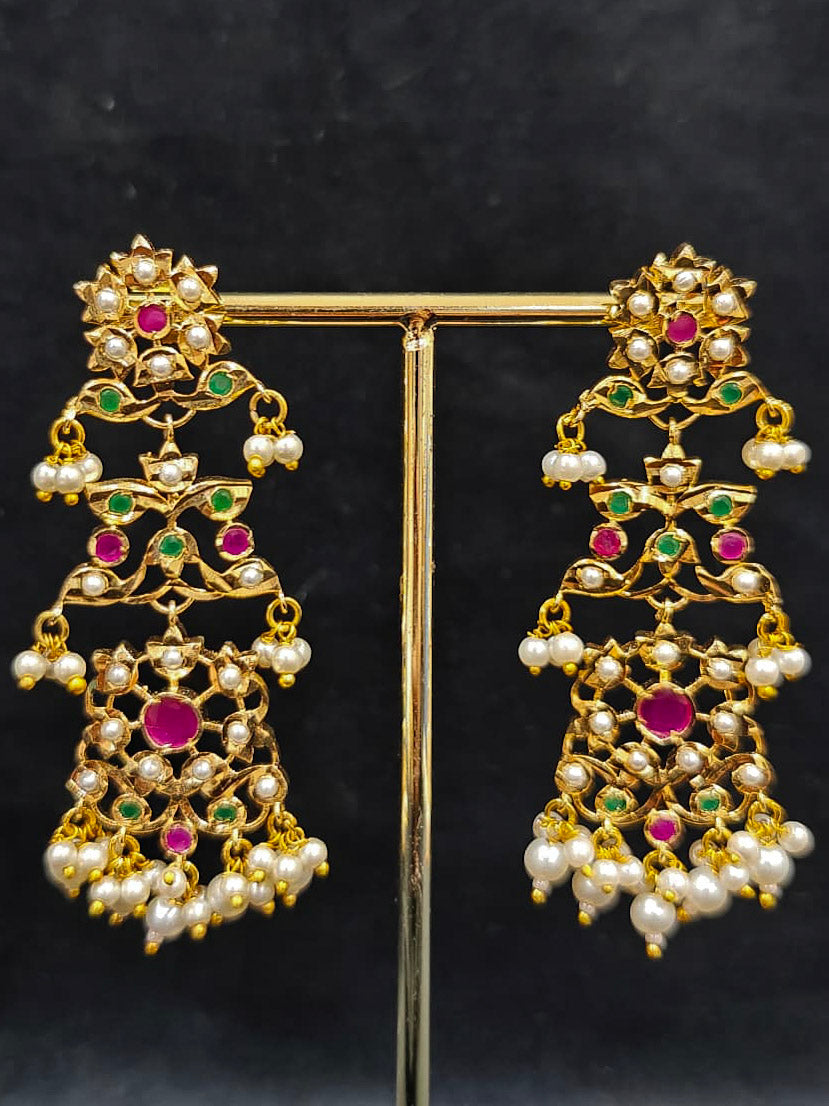 Close-up of an ornate traditional collar Ruby Pink and Green  jadau gold jewellery set and jadau earrings with pearls and Navratan gemstones. Royal Jadau necklace for festive events in India. Festive celebration look featuring a Jadau artificial necklace.