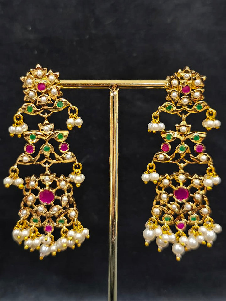 Close-up of an ornate traditional collar Ruby Pink and Green  jadau gold jewellery set and jadau earrings with pearls and Navratan gemstones. Royal Jadau necklace for festive events in India. Festive celebration look featuring a Jadau artificial necklace.