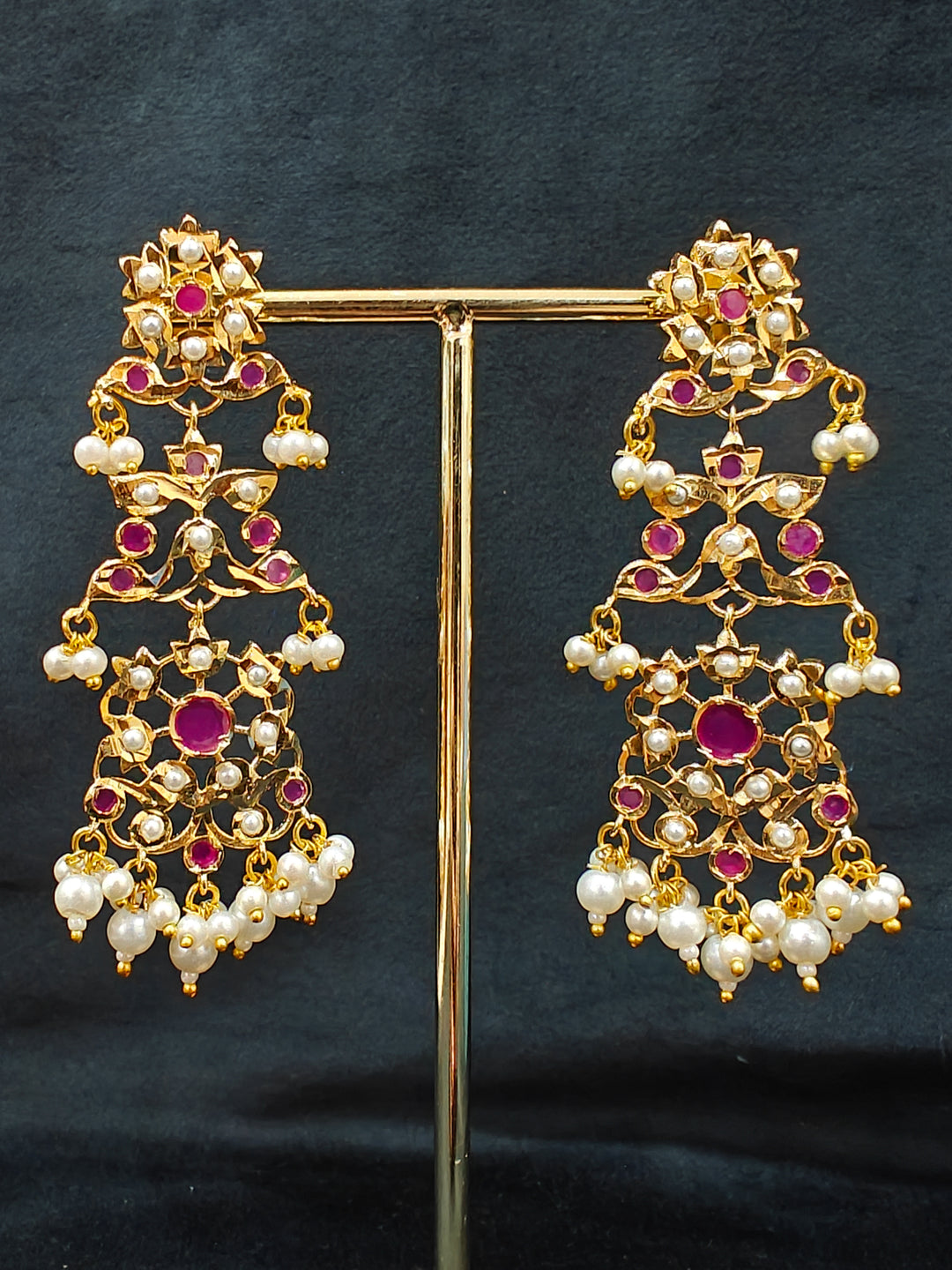 Close-up of an ornate traditional Ruby Pink jadau gold jewellery set and jadau earrings with pearls and stones. Elegant reception look featuring a luxury Jadau artificial jewelry set. Perfect Jadau necklace set for weddings and festivals. 