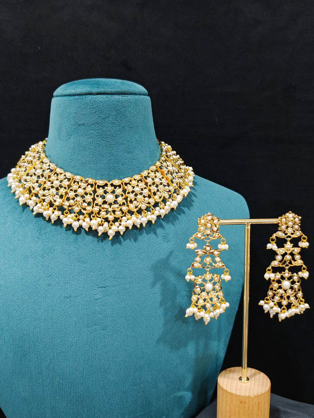 Close-up of a gold Indian traditional White jadau jewellery with pearls and jadau stones, and matching jadau earrings. This authentic jadau jewelry set can we worn as jadau necklace set for weddings. Close-up of high-quality Jadau artificial necklace craftsmanship. Festive celebration look featuring a Jadau artificial necklace.