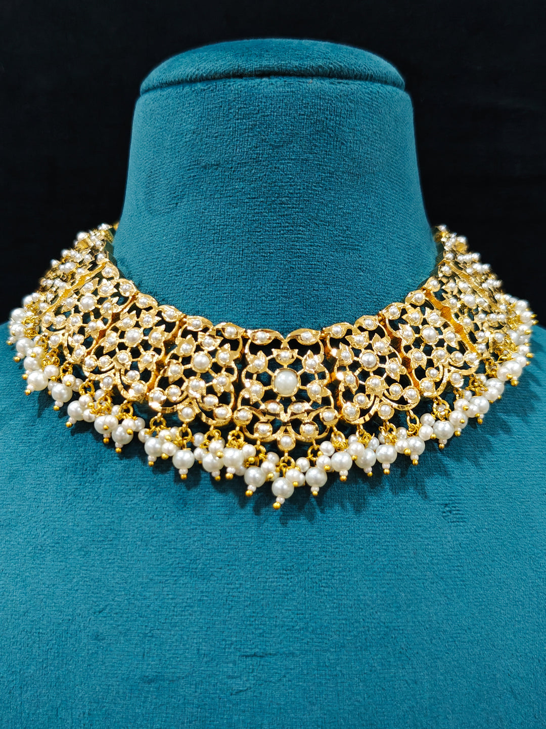 Close-up of a gold Indian traditional White jadau jewellery with pearls and jadau stones, and matching jadau earrings. This authentic jadau jewelry set can we worn as jadau necklace set for weddings. Close-up of high-quality Jadau artificial necklace craftsmanship. Festive celebration look featuring a Jadau artificial necklace.