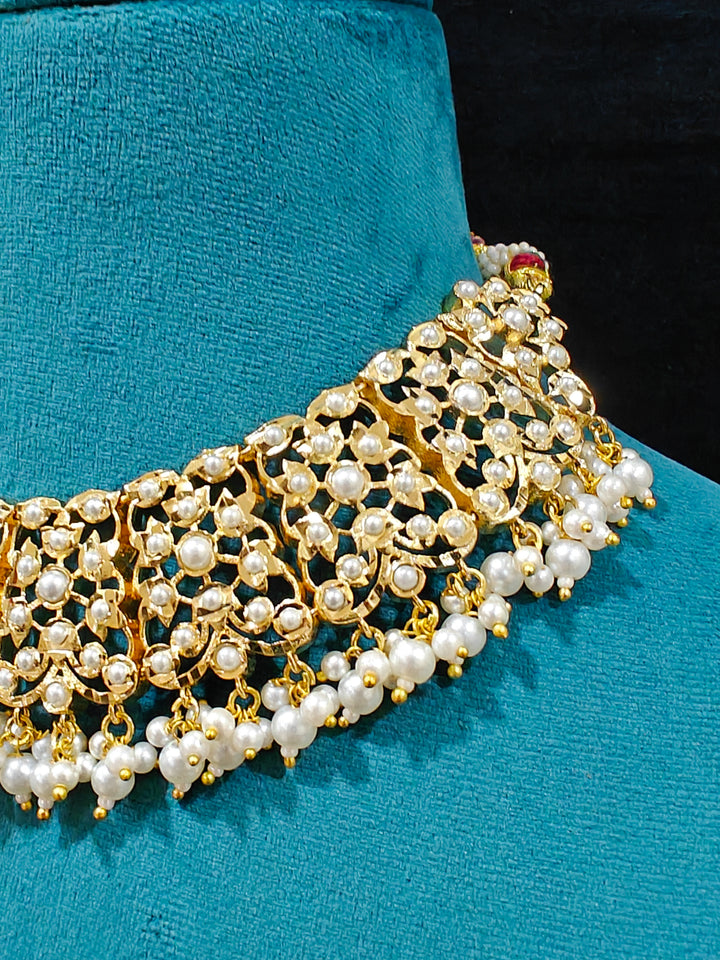 Close-up of a gold Indian traditional White jadau jewellery with pearls and jadau stones, and matching jadau earrings. This authentic jadau jewelry set can we worn as jadau necklace set for weddings. Close-up of high-quality Jadau artificial necklace craftsmanship. Festive celebration look featuring a Jadau artificial necklace.