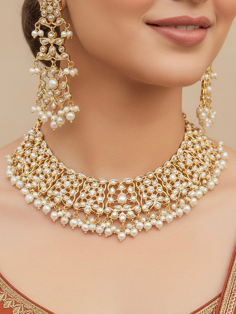 Close-up of a woman wearing a gold Indian traditional jadau jewellery with pearls and jadau stones, and matching jadau earrings. This authentic jadau jewelry set can we worn as jadau necklace set for weddings. 