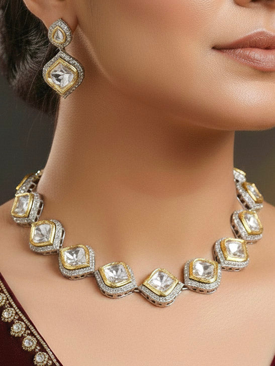 A woman with long dark hair wears the Moissanite Susan Necklace Set—gold and silver Kundan necklace surrounded by American Diamonds, with matching earrings—gazing neutrally at the camera, effortlessly highlighting this luxury jewelry.