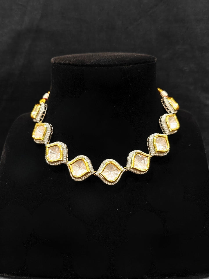 The Moissanite Susan Necklace Set—gold and silver Kundan necklace surrounded by American Diamonds, with matching earrings—gazing neutrally at the camera, effortlessly highlighting this luxury jewelry. Woman wearing trending Kundan artificial jewelry for wedding season in India. Festive saree styling with a premium artificial Kundan necklace.