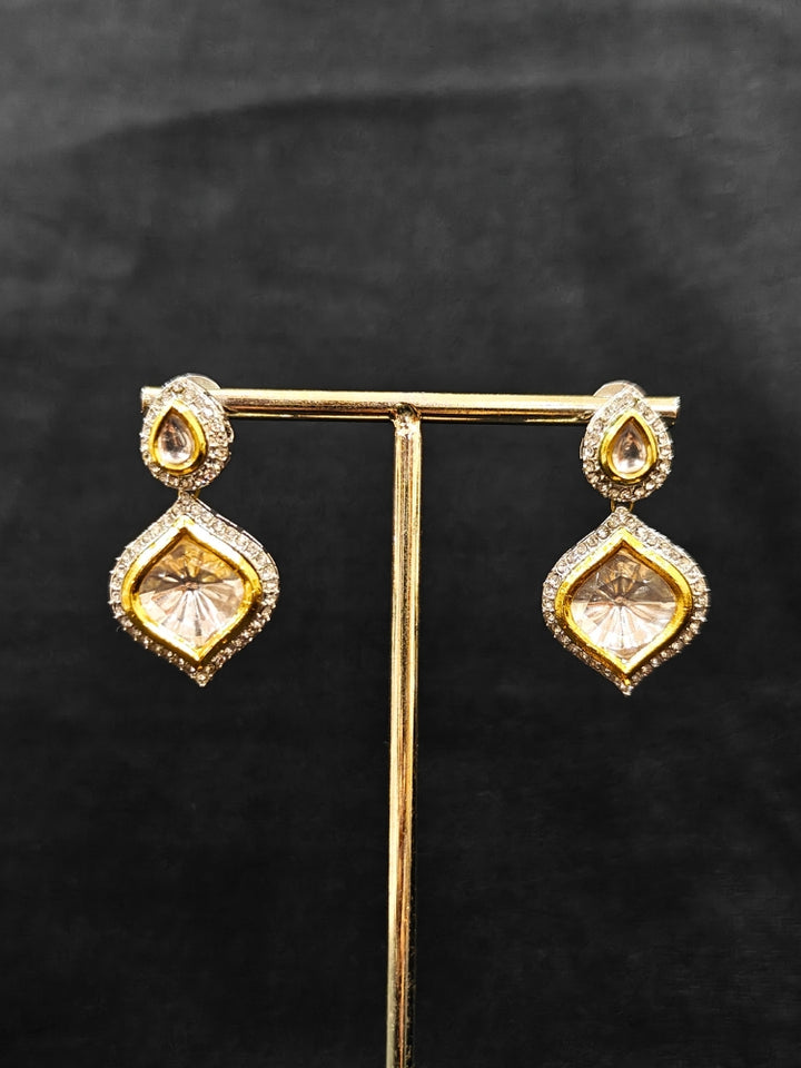 The Moissanite Susan Necklace Set—gold and silver Kundan necklace surrounded by American Diamonds, with matching earrings—gazing neutrally at the camera, effortlessly highlighting this luxury jewelry. Woman wearing trending Kundan artificial jewelry for wedding season in India. Festive saree styling with a premium artificial Kundan necklace.