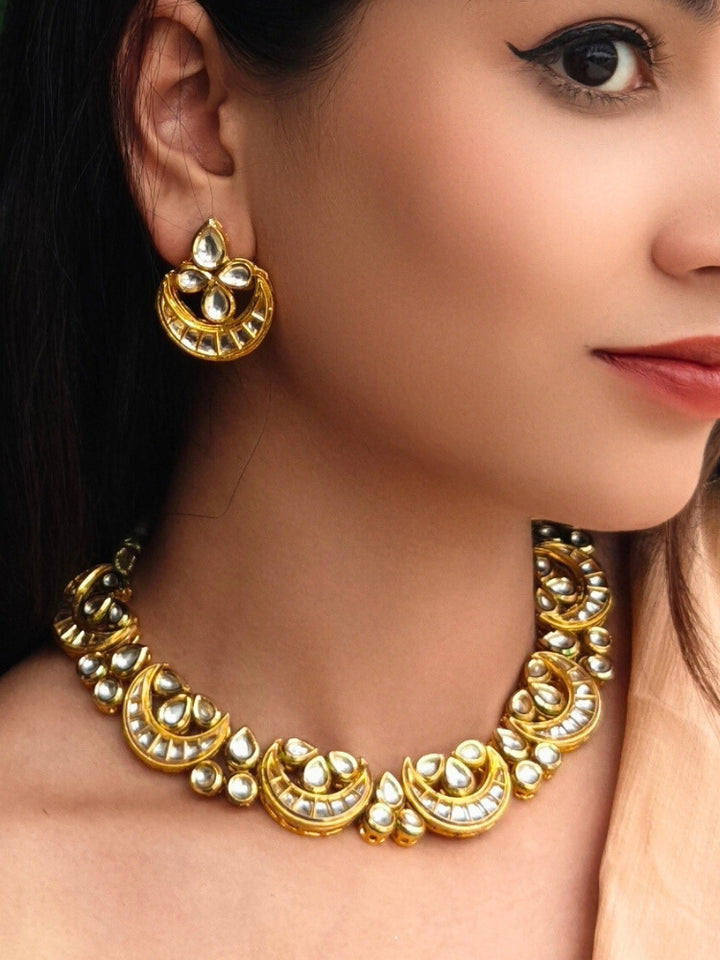 Close-up of a woman wearing an ornate traditional (Gold Polish) Collar Kundan jewellery set and earrings with Kundan. Wedding guest wearing a lightweight Kundan necklace for a festive function. Festive saree styling with a premium artificial Kundan necklace.