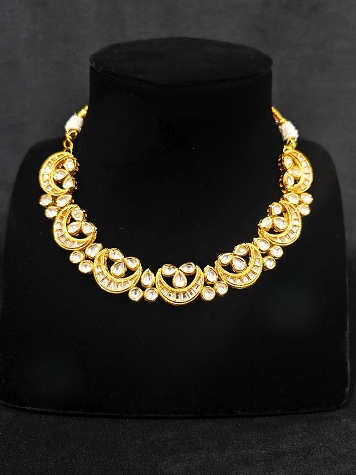 Close-up of an ornate traditional (Gold Polish) Collar Kundan jewellery set and earrings with Kundan. Wedding guest wearing a lightweight Kundan necklace for a festive function. Festive saree styling with a premium artificial Kundan necklace.