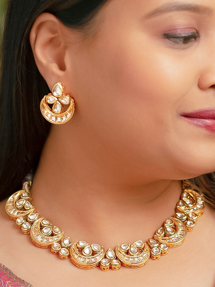 Close-up of a woman wearing an ornate traditional (Gold Polish) Collar Kundan jewellery set and earrings with Kundan. Wedding guest wearing a lightweight Kundan necklace for a festive function. Festive saree styling with a premium artificial Kundan necklace.