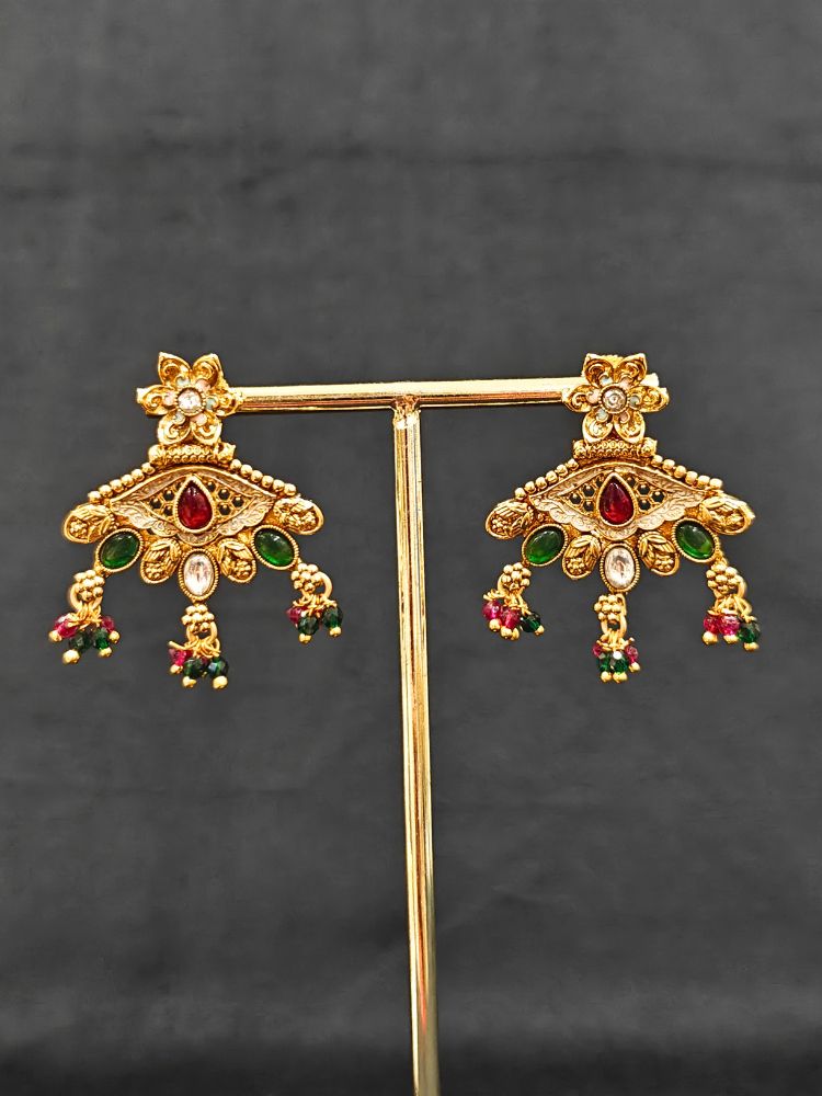 Close-up of an ornate traditional (Gold Polish) Pink & Green Collar jewellery set and earrings with Crystal Beads, Meenakari, Pearl and Colored Stone. Bride wearing a high-quality artificial Meenakari jewelry set for wedding rituals. Woman wearing lightweight artificial Meenakari jewelry for long wedding functions.