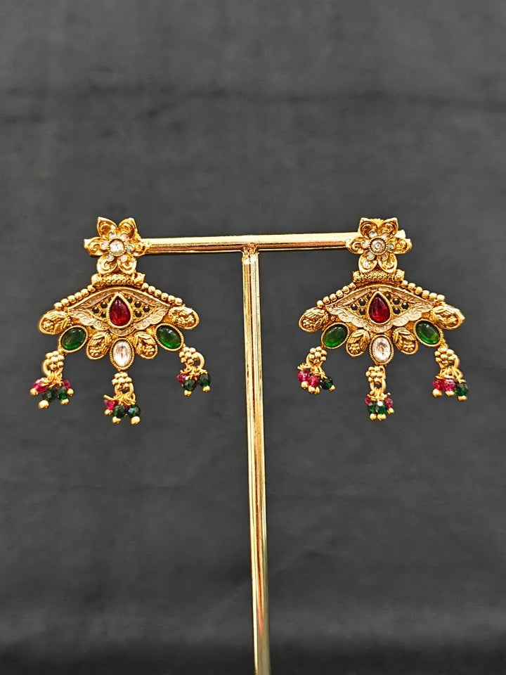 Close-up of an ornate traditional (Gold Polish) Pink & Green Collar jewellery set and earrings with Crystal Beads, Meenakari, Pearl and Colored Stone. Bride wearing a high-quality artificial Meenakari jewelry set for wedding rituals. Woman wearing lightweight artificial Meenakari jewelry for long wedding functions.