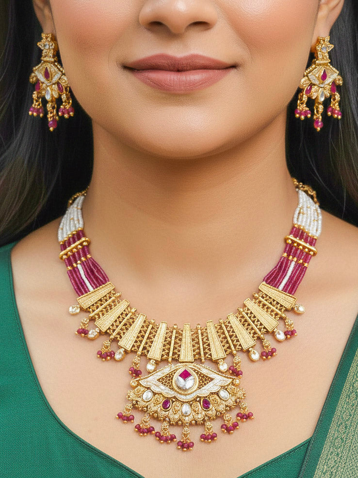 Close-up of a woman wearing an ornate traditional (Gold Polish) Pink Collar jewellery set and earrings with Crystal Beads, Meenakari, Pearl and Colored Stone. Bride wearing a high-quality artificial Meenakari jewelry set for wedding rituals. Woman wearing lightweight artificial Meenakari jewelry for long wedding functions.