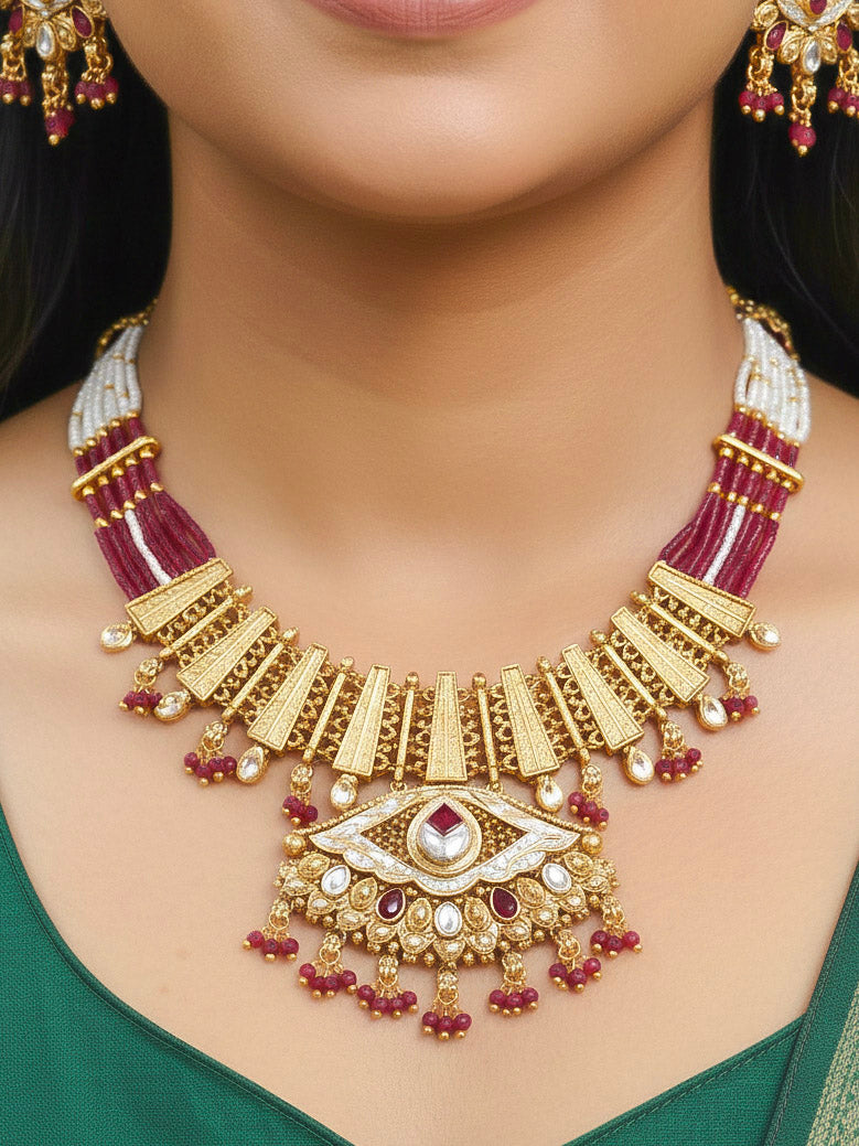 Close-up of a woman wearing an ornate traditional (Gold Polish) Pink Collar jewellery set and earrings with Crystal Beads, Meenakari, Pearl and Colored Stone. Bride wearing a high-quality artificial Meenakari jewelry set for wedding rituals. Woman wearing lightweight artificial Meenakari jewelry for long wedding functions.