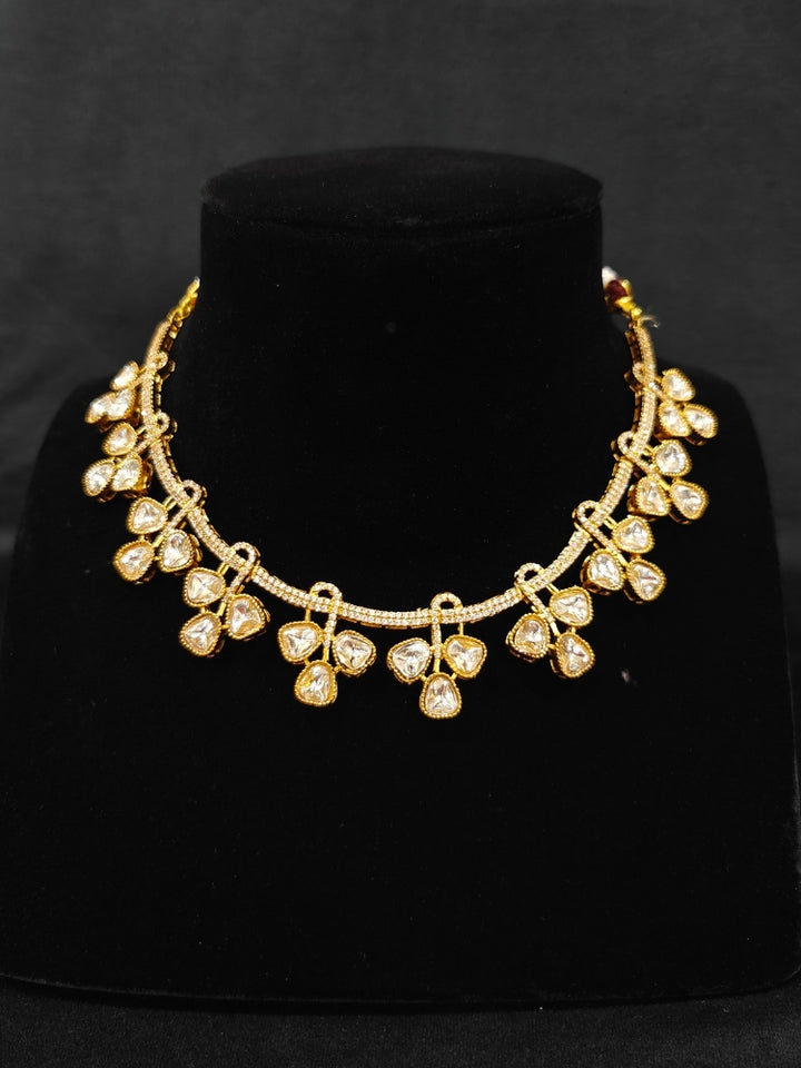 A sparkling artificial diamond and polki necklace and diamond earrings set, designed to offer a radiant, elegant look for any formal occasion or Indian wedding. This affordable diamond jewelry provides a flawless, luxurious alternative to natural diamonds.